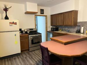 a kitchen with a table and a refrigerator at The Water Street House in Port Huron