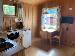 Una pequeña cocina con una mesa y una ventana. en Veganeset Camping, en Balestrand