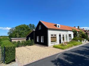 a black and white house on the side of a road at Dijkhuis Driepolders in Biervliet