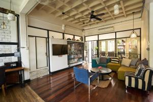 a living room with a couch and a tv at Sherloft Home & Hostel in Chiang Mai