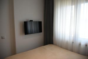 um quarto com uma cama e uma televisão na parede em Zlatibor Prestige Apartman 18 em Zlatibor