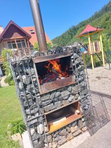 a fire in a grill with a playground in the background at Dor de Munte Transfăgarasan in Cârțișoara