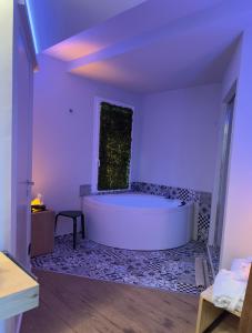 a large white bath tub in a room with purple lighting at URBAN PRIVATE SPA in Porto SantʼElpidio
