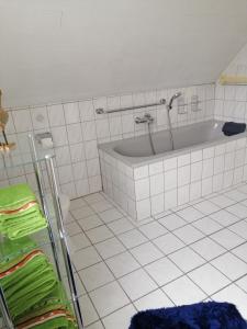 a white bathroom with a tub and a towel rack at Haus Weda in Krummhörn +22 photos
