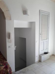 Camera bianca con porta e pavimento piastrellato. di Casa vacanza Elias a Ceglie Messapica