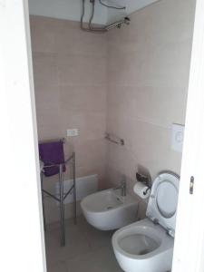 un bagno bianco con un water e un lavandino di Casa vacanza Elias a Ceglie Messapica