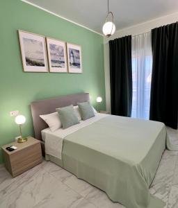 ミラッツォにあるMilazzo Blu Fronte Spiaggia, Vista Eolie Verdeの緑の壁のベッドルーム1室(大型ベッド1台付)