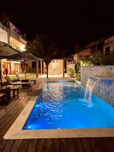 una piscina por la noche con una fuente de agua en Bali BG Casa Bamboo, en Barra Grande