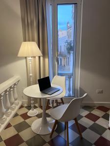 a laptop sitting on a table in a room with a window at La Valigia sul letto in Mesagne