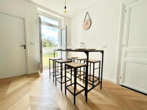 a table and chairs in a room with a window at Appart Cosy Proche gare in Mantes-la-Jolie +14 photos