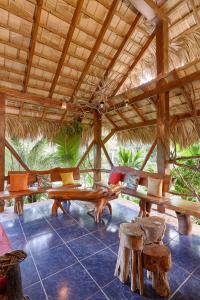 a pavilion with benches and tables in a resort at CHALET TROPICAL Hotel & Restaurant-Pizzeria in Las Galeras