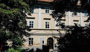 a large white building with a door and trees at Old town luxury segment in Braşov