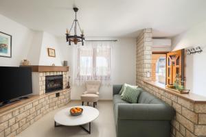 a living room with a couch and a tv at Holiday Home Fažana 1931 in Fažana