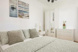 a white bedroom with a bed and a dresser at Holiday Home Fažana 1931 in Fažana