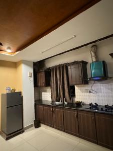 a kitchen with a counter top and a refrigerator at Condo In Islamabad in Islamabad