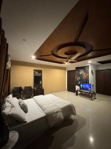 a bedroom with a large bed and a ceiling at Condo In Islamabad in Islamabad