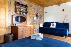 a living room with a blue couch and a tv at Biała Kalina Kaczawy in Świerzawa