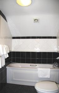 a bathroom with a white toilet and a bath tub at Boot & Shoe Inn in Greystoke