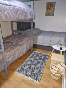a room with two bunk beds and a rug at Guest House Waterfall Theth in Shkodër