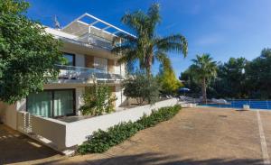 a house with a palm tree in front of it at Kamena Residence in Marina di Ragusa