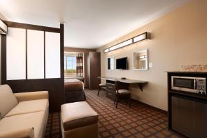 Habitación de hotel con sofá y mesa en Microtel Inn & Suites Cotulla, en Cotulla