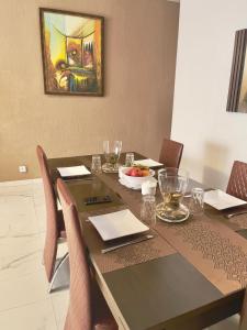 a dining room table with chairs and a painting on the wall at Apart Teranga Dakar Plateau in Dakar +21 photos