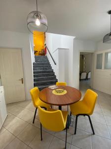 a dining room with a table and yellow chairs at Stella's House in Mytilinioí