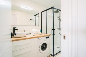 a bathroom with a washing machine and a glass shower at Almare Suites - Aguadulce Vistas al mar in Aguadulce +20 photos