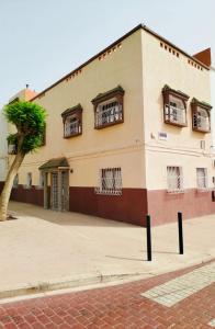 a building with windows and a tree in front of it at Maison Traditionnelle à 10mnt de la plage in Agadir