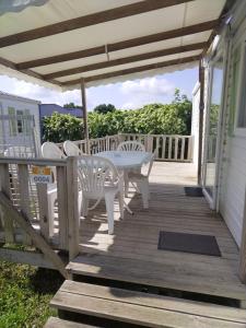 a wooden deck with a table and chairs on it at Mobile home proche Europapark et rulantica proche allemagne in Boofzheim