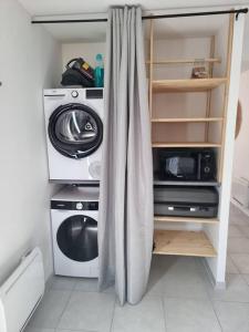 eine Küche mit Waschmaschine und Mikrowelle in der Unterkunft Maison cosy aux portes de Tours in Saint-Pierre-des-Corps + 5 Fotos
