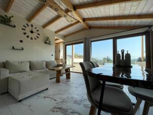 a living room with a table and a couch and a clock at Serenity in Samos
