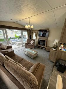 a living room with a couch and a table at Golden Palm Resort - The Superior Retreat - Coastal Caravan Breaks in Chapel Saint Leonards