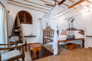 a bedroom with a bed with a canopy at Waterlovers Beach Resort in Diani Beach