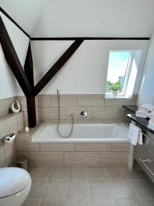 a bathroom with a bath tub and a toilet at Wohnung im Schloss in Todendorf +20 photos