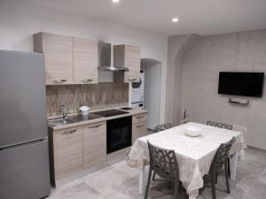 a kitchen with a table and a sink and a refrigerator at MIA GUEST ROOM in Triggiano