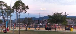 a playground in a park with people sitting on benches at Apartma Panorama in Žusterna