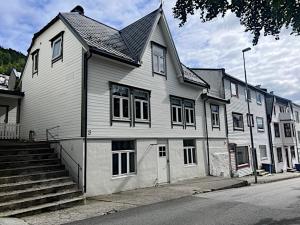 a large white house with stairs in front of it at Koselig leilighet i Ålesund sentrum in Ålesund