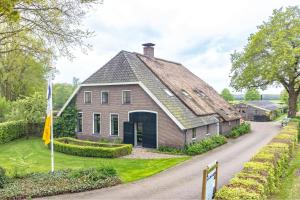 a large brick house with a gambrel roof at Tipi tent in Sleen