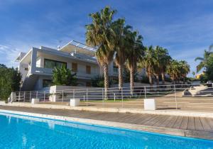 a large white swimming pool in front of a house at Kamena Residence in Marina di Ragusa