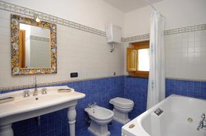 uma casa de banho com um lavatório, um WC e uma banheira em Casa Rossa em Ravello