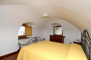 a bedroom with a yellow bed and a window at Casa Rossa in Ravello