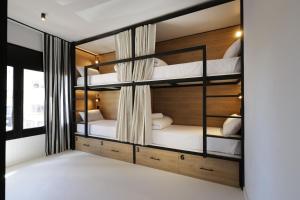 a room with four bunk beds in a room at BLACK AND WHITE Hostel Palamós in Palamós +14 photos