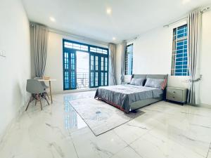 a large bedroom with a bed and large windows at Lotus Homestay in Sihanoukville