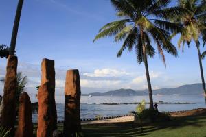 a view of a beach with palm trees and the ocean at Sea Breeze Candidasa in Candidasa