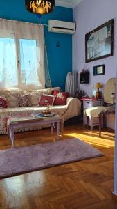 a living room with a couch and a table at cozy διαμέρισμα με υπέροχη θέα ! in Athens
