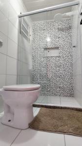 a bathroom with a toilet and a glass shower at Casa Espaço Sara Piscina Aquecimento Solar total privacidade, área gourmet completa com churrasqueira fogão a lenha, a 5min do centro e do parque das águas in São Lourenço