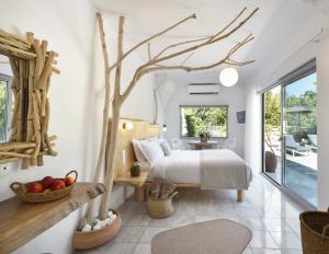 ein Schlafzimmer mit einem Bett und einem Baum in der Unterkunft Olympa Suites in Plaka + 77 Fotos