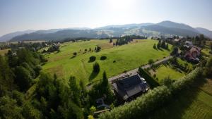 an aerial view of a large green field with a house at Górski Azyl w Soblówce in Sablówka +48 photos