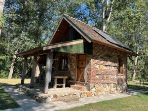 a small log cabin with a wooden door in a park at Vikendica Drina Mladenova suma in Čajići